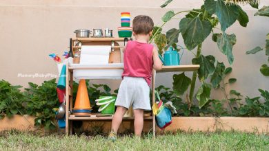 toddler playing with mud kitchen